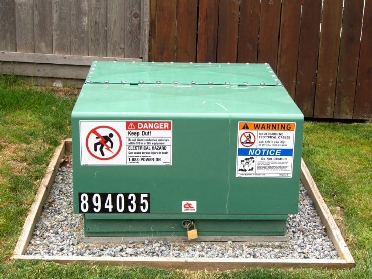 Green electrical transformer box in yard